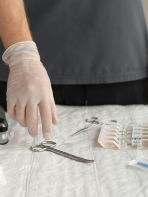 Close-up of hands in latex gloves arranging medical tools on a table.