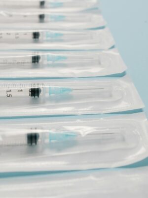 High-quality image of sterile packed syringes perfectly aligned on a blue background, highlighting medical preparedness.