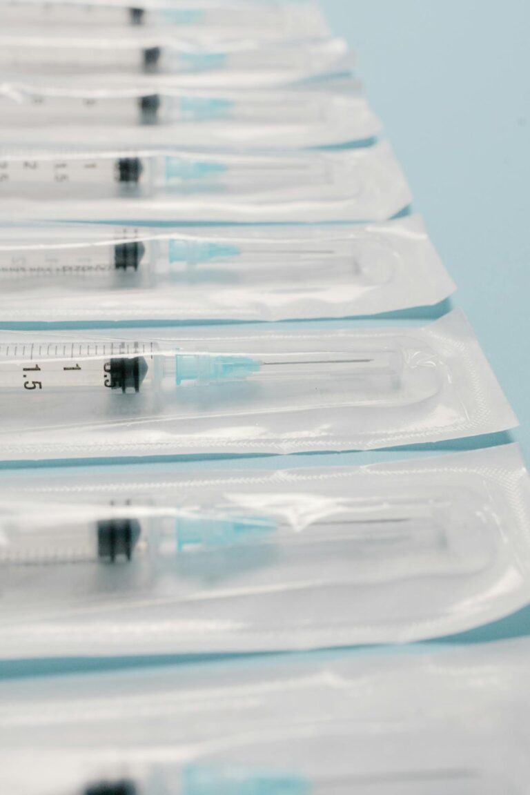 High-quality image of sterile packed syringes perfectly aligned on a blue background, highlighting medical preparedness.