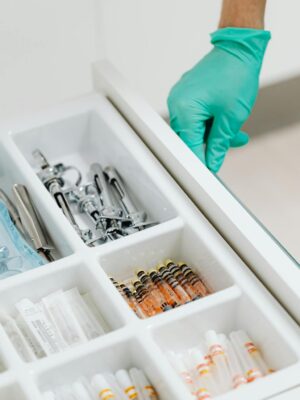 Sterile drawer with medical instruments and syringes in a clinic setting.