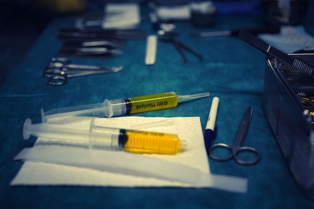 A detailed view of surgical instruments and syringes on a hospital table.