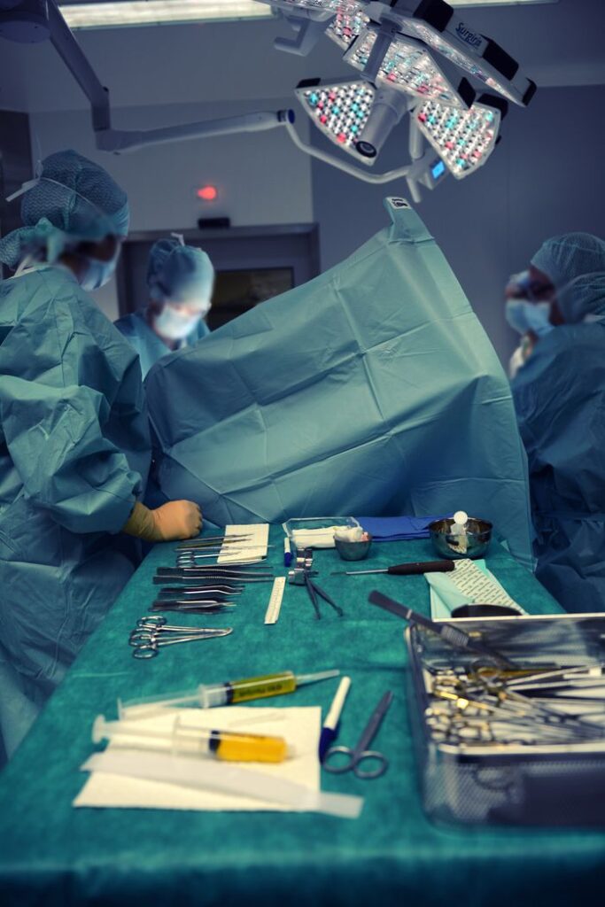 A team of surgeons in an operating room using various surgical instruments.